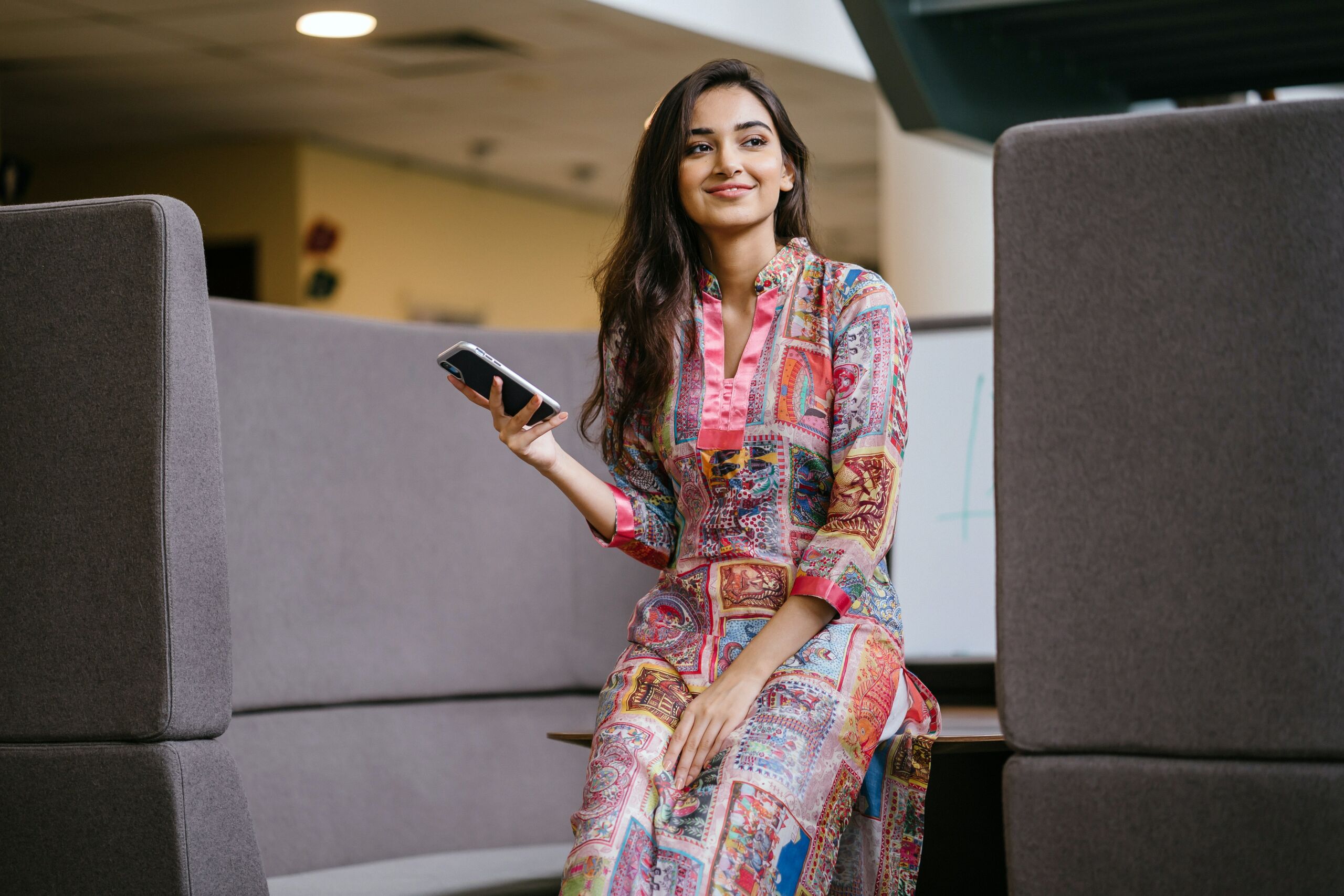 Email en anglais professionnel eviter les erreurs smartphone Un femme d'affaires souriante envoie un email en anglais sans erreurs linguistiques